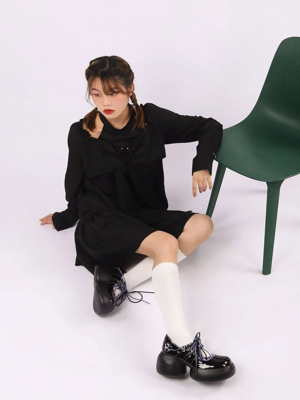 Alternative streetwear outfit with black patent purple leopard platform Oxford shoes on seated model