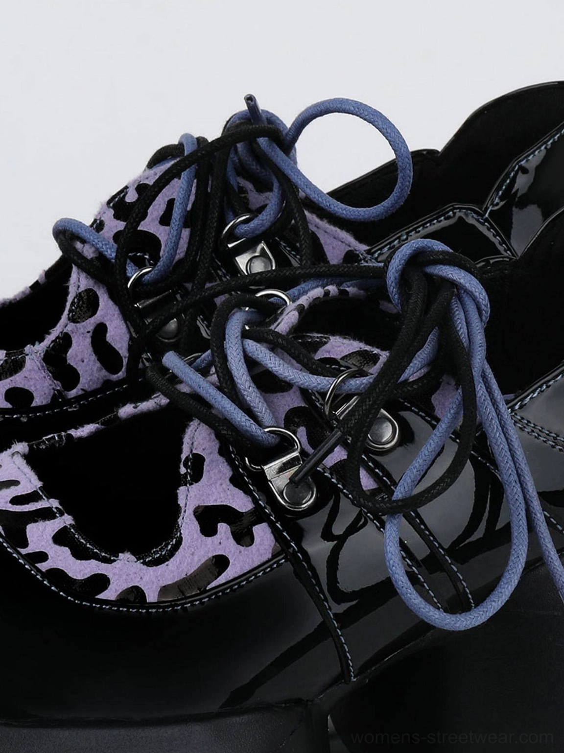 Close-up of silver eyelets, purple leopard print vamp panels, and blue-purple laces on patent platform Oxford shoes