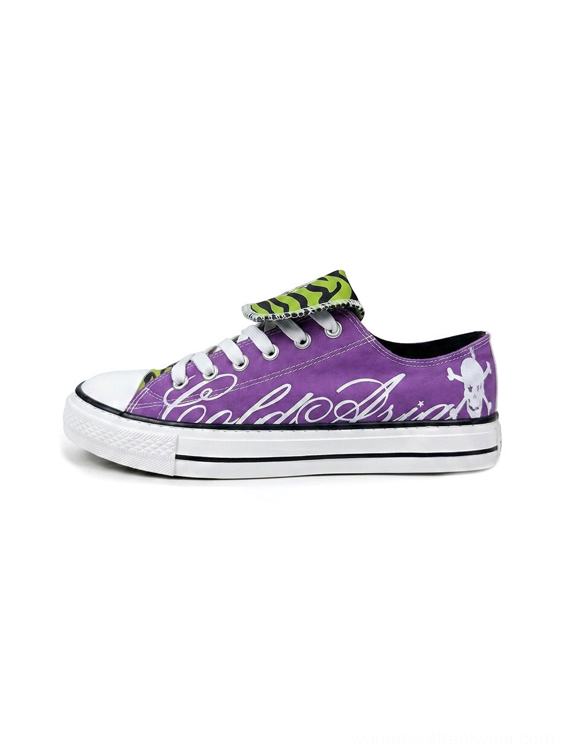 Front view of purple low top canvas sneakers with white cursive side graphics, green black zebra print tongues, white rubber toe caps, and skull heel details