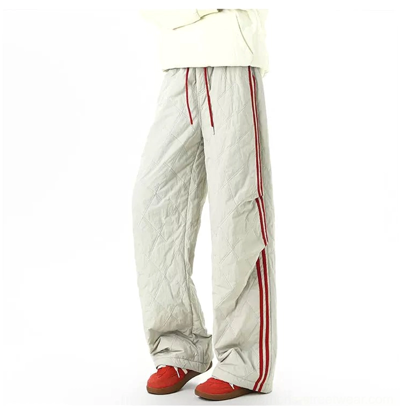 Light gray quilted wide-leg track pants with red double side stripes styled with a cream top and red sneakers