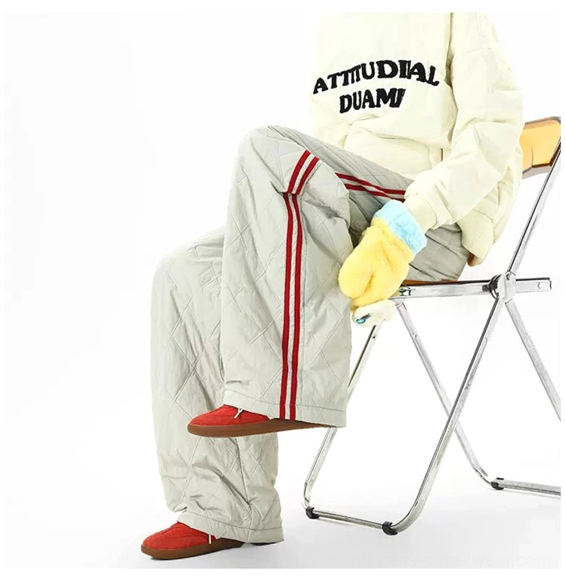 Gray quilted warm-up pants with red double racing stripes shown from the side in a loose wide-leg silhouette