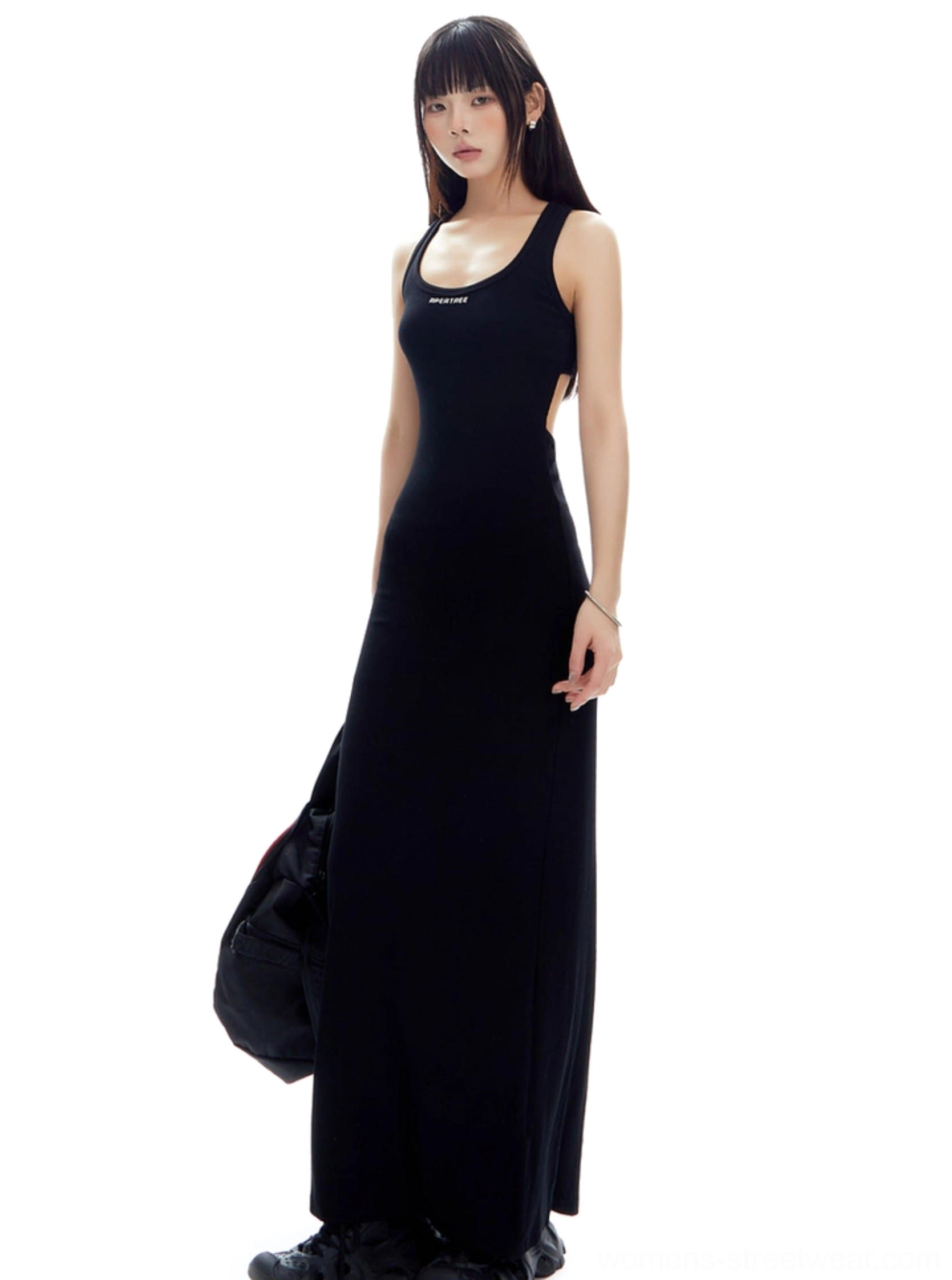 Black open back racerback ribbed maxi dress shown from a left rear three quarter angle