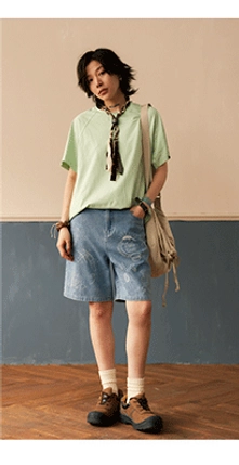 Raglan sleeve crew neck t-shirt detail view showcasing double-layered collar construction and raw edge sleeve finishing