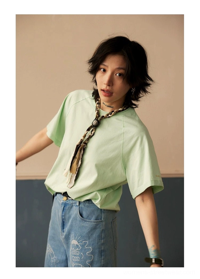 Full body model shot wearing raglan crew neck t-shirt with experimental layering and contemporary street style accessories