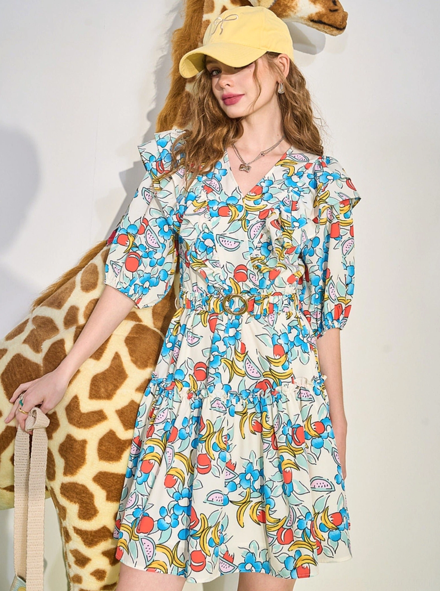 Side outfit view of rainbow fruit print ruffle mini dress with elastic waist and feminine tiered skirt