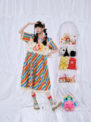 Three-quarter view of a colorful rainbow stripe teddy bear dress for girls showing the sailor-inspired collar layered skirt and playful kawaii party style