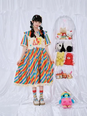 Front view of a girls rainbow stripe teddy bear party dress with navy doll collar cartoon bear print tiered skirt and colorful polka dot trim