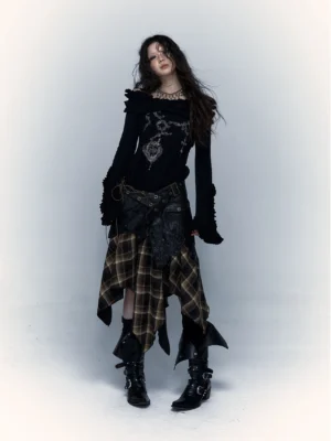 Full front view of women’s brown plaid asymmetrical handkerchief hem skirt styled with an off shoulder knit top and biker boots