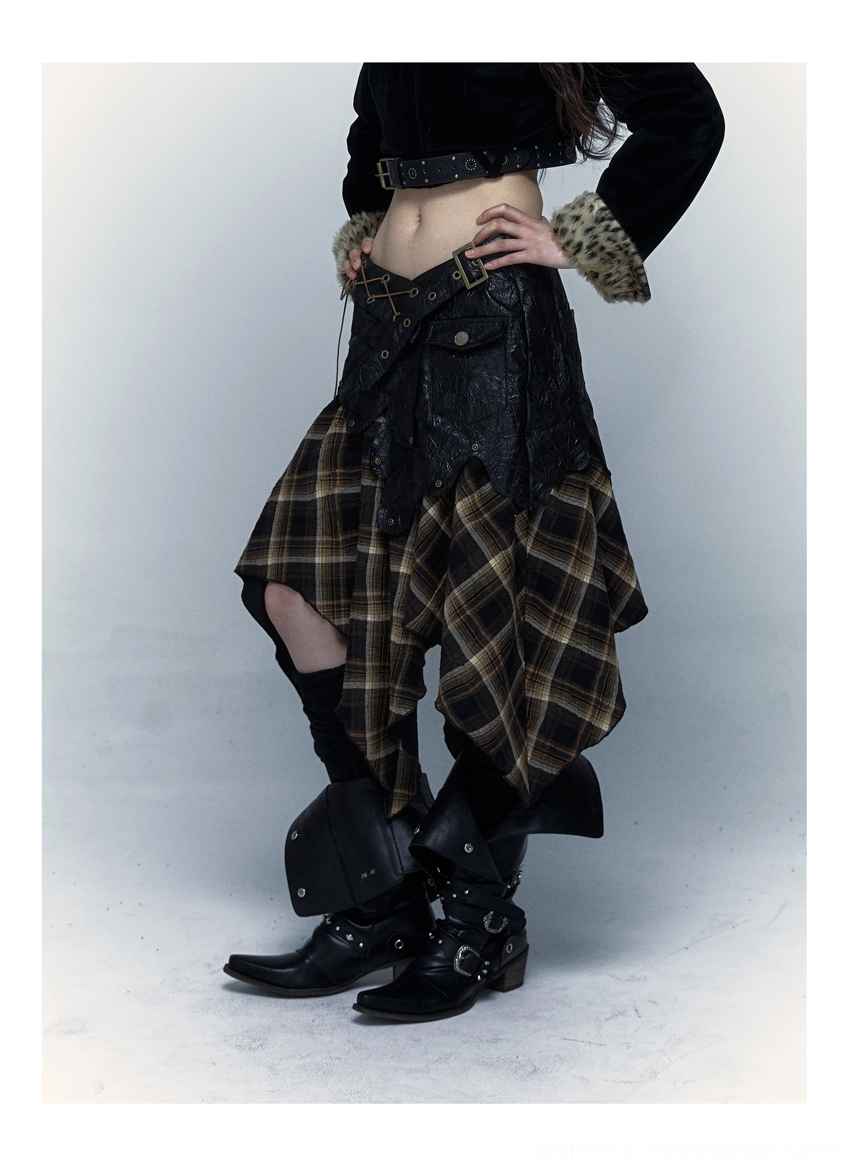 Side view of women’s tartan asymmetrical streetwear skirt showing the irregular plaid hem and dark faux leather waist panel