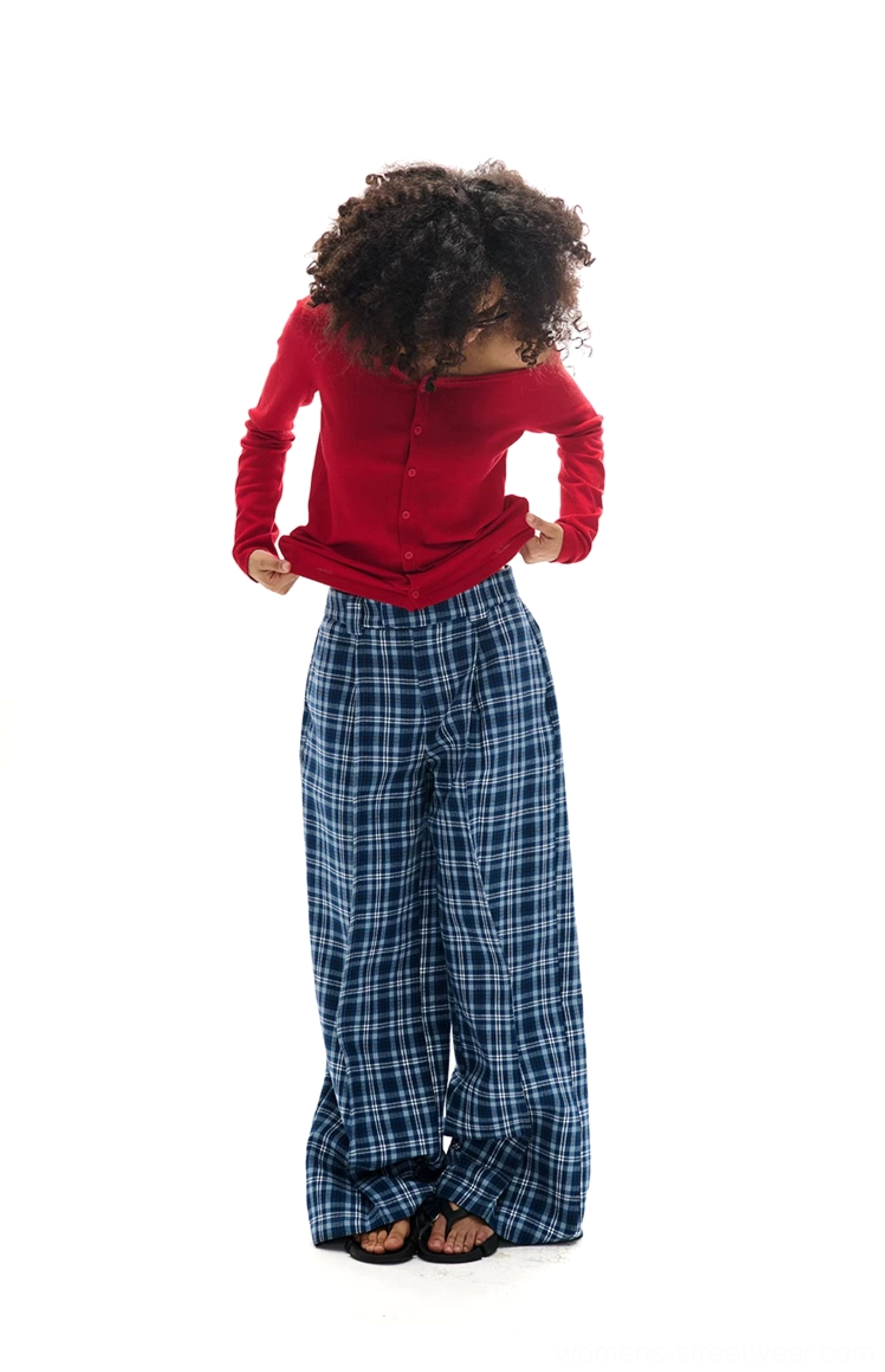 Back view of a red asymmetrical off-shoulder button-front knit cardigan with fitted long sleeves