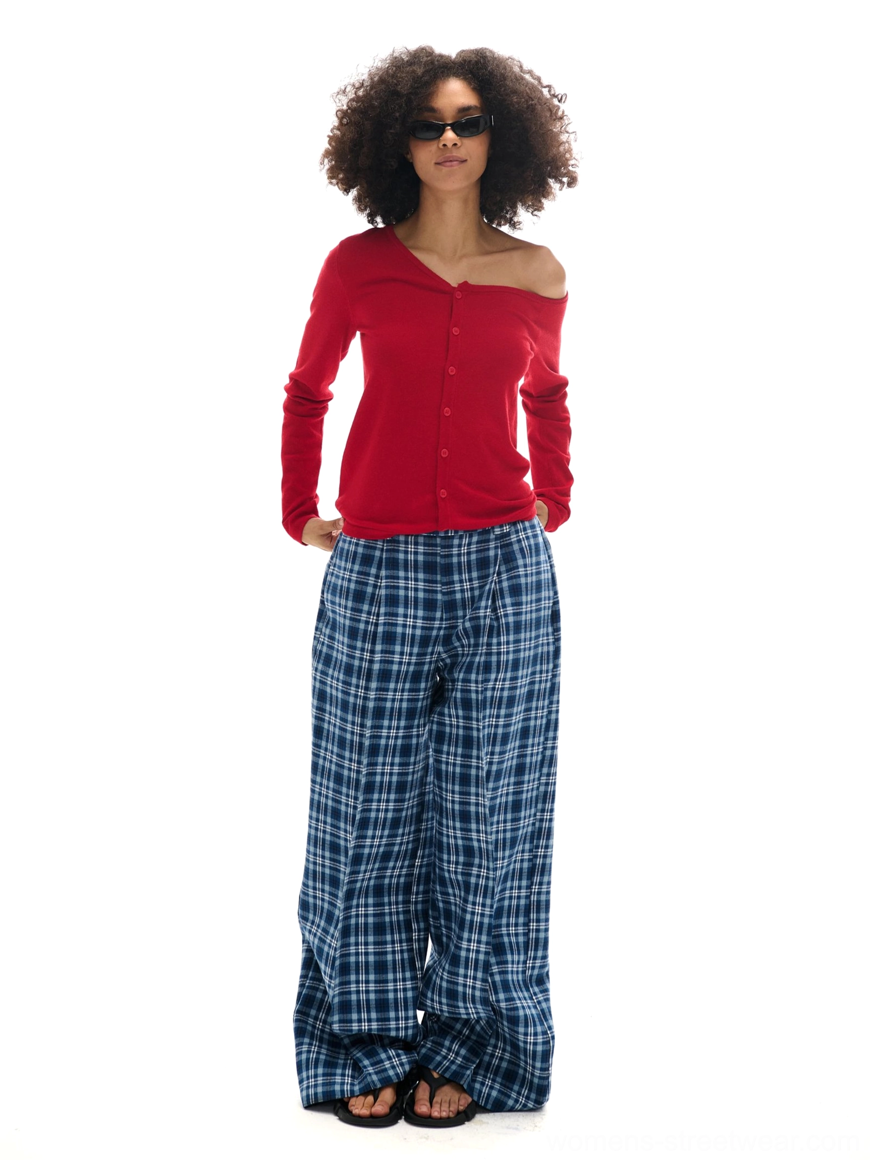 Bright red asymmetrical off-shoulder button-front knit cardigan paired with blue plaid wide-leg pants