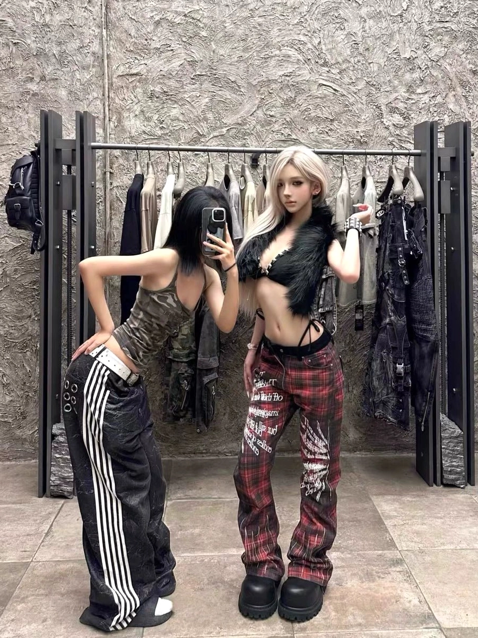 Side view of red black tartan flare streetwear pants with wing prints and gothic lettering styled with platform boots