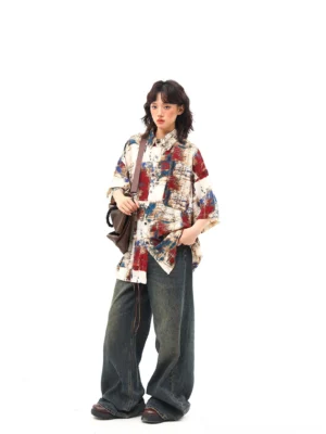 Oversized abstract print button up shirt in red blue and tan shown in a three quarter streetwear outfit view
