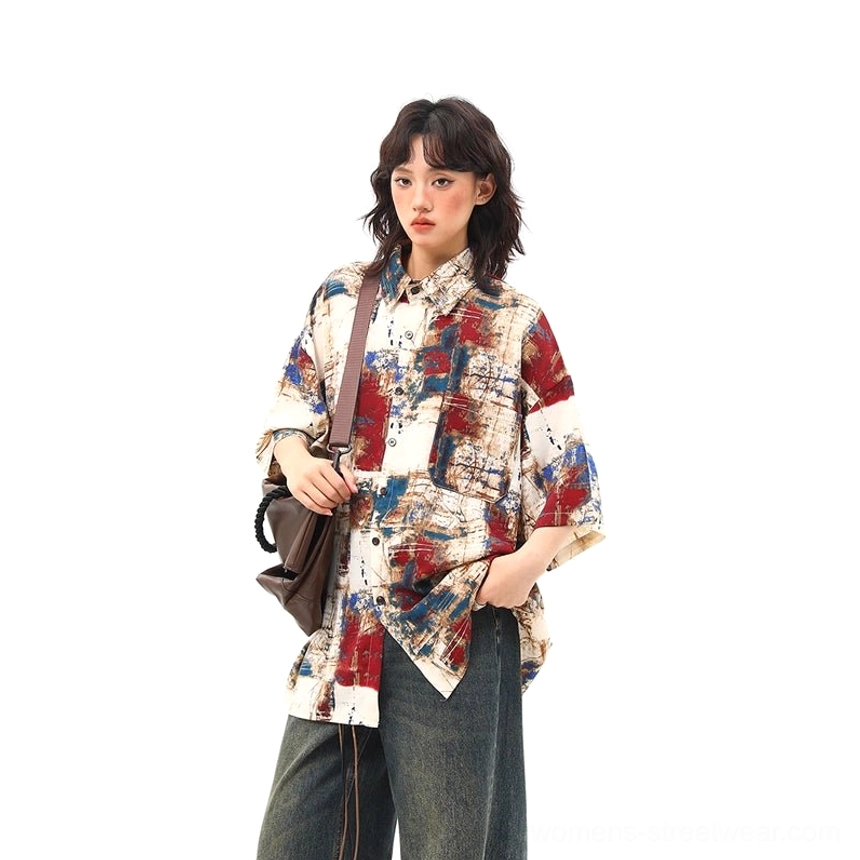 Red abstract print oversized button up shirt front three quarter view with blue brushstroke graphics and shoulder bag