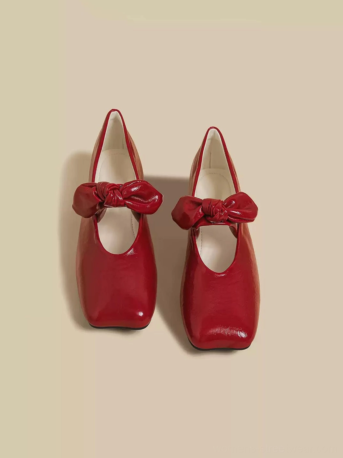Red bow square-toe flats showing the shoe opening, prominent instep bow, textured upper, and modern Mary Jane silhouette