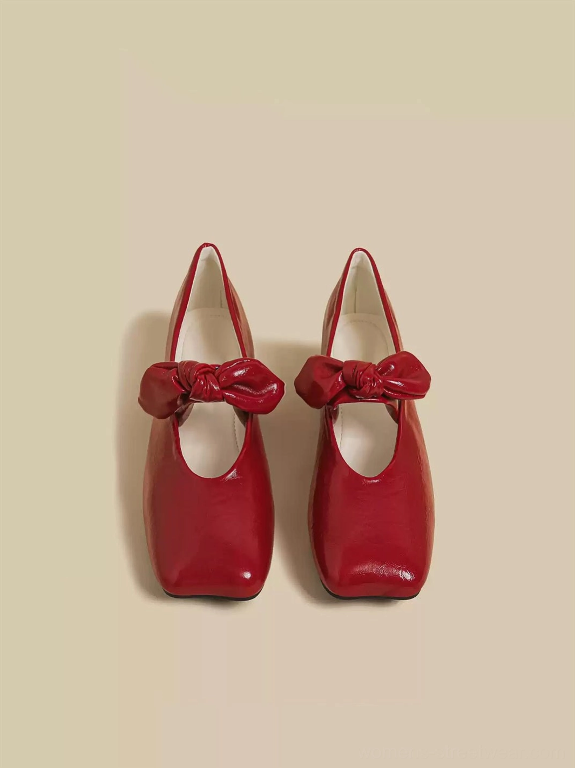 Pair of red bow square-toe strap flats shown from above with padded bow detail, closed toe, and flat rubber sole
