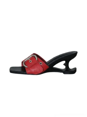 Side view of red buckle strap sculptural wedge slide sandals with silver eyelet hardware, square open toe, and curved black wedge sole