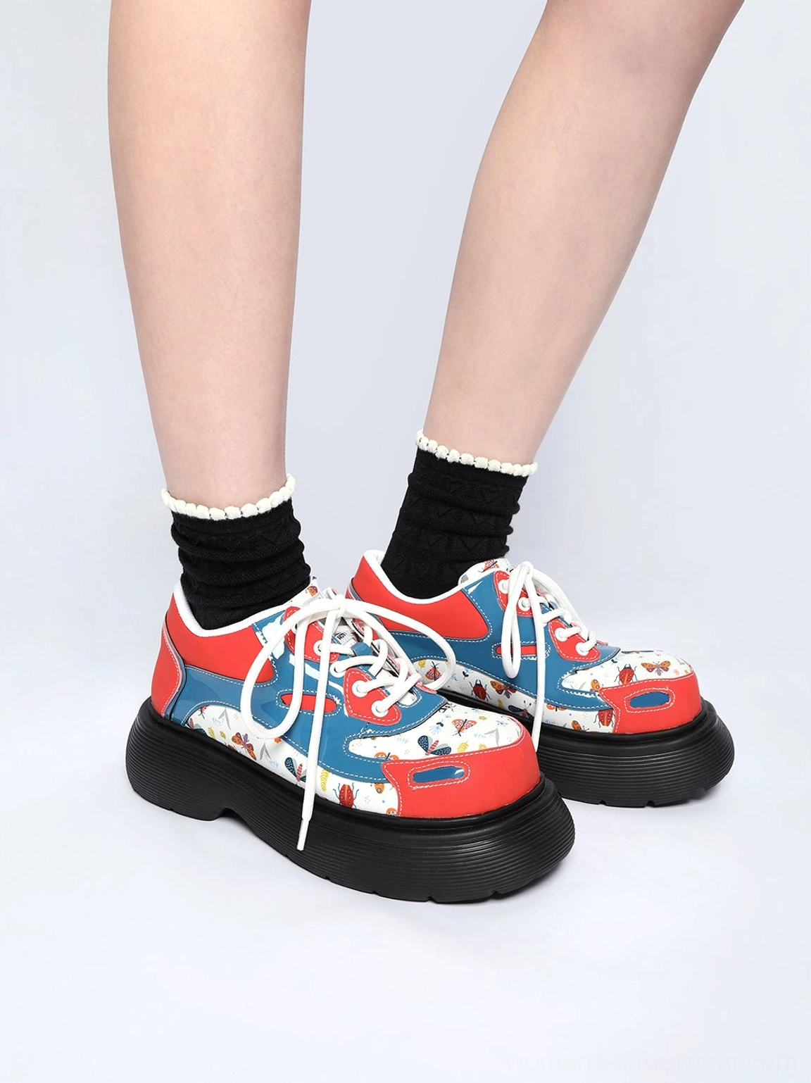Women's red butterfly platform derby shoes styled with black ankle socks in a low front view