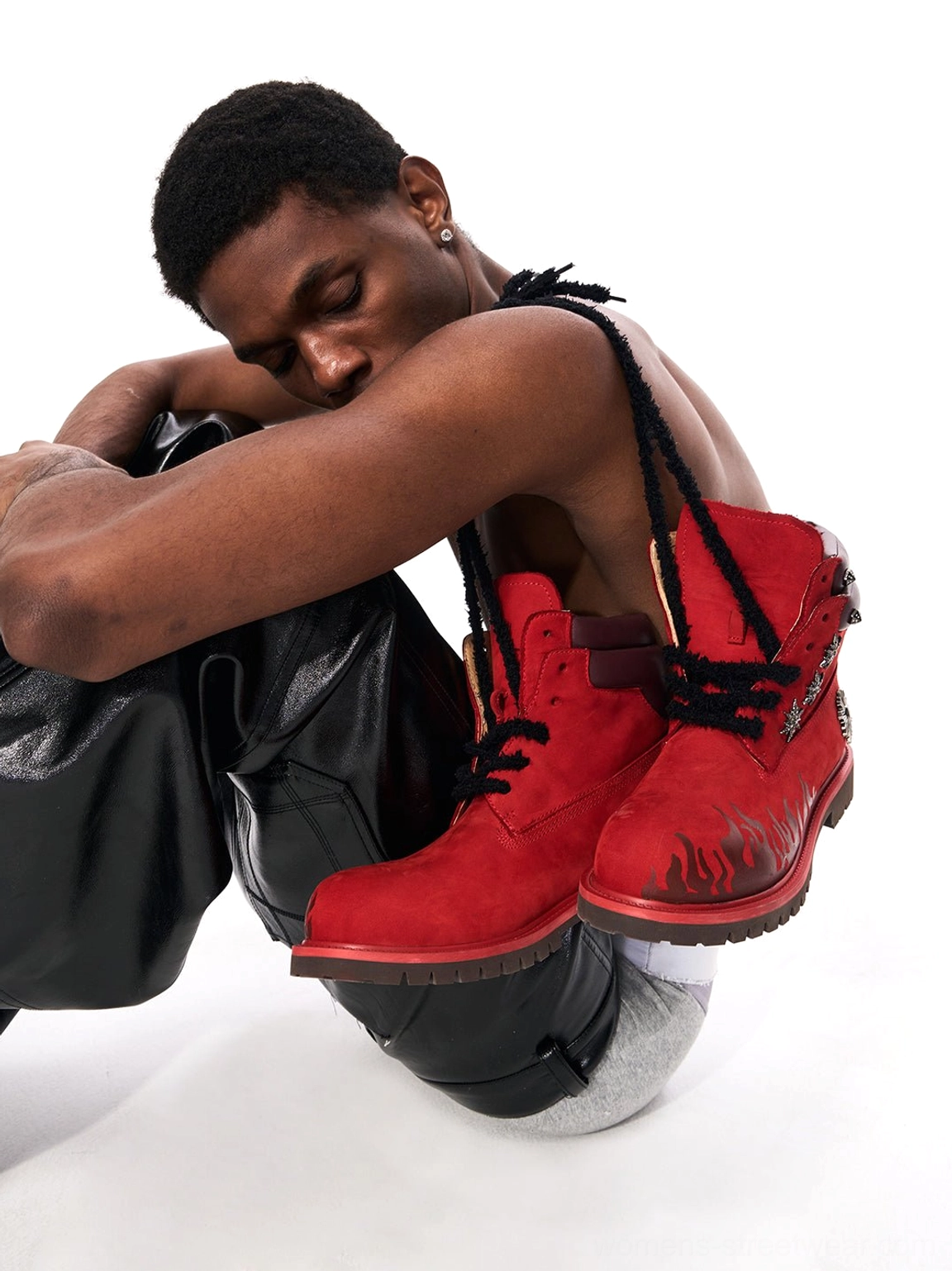 Red flame appliqué genuine leather combat boots displayed with black leather pants for rebellious punk streetwear styling