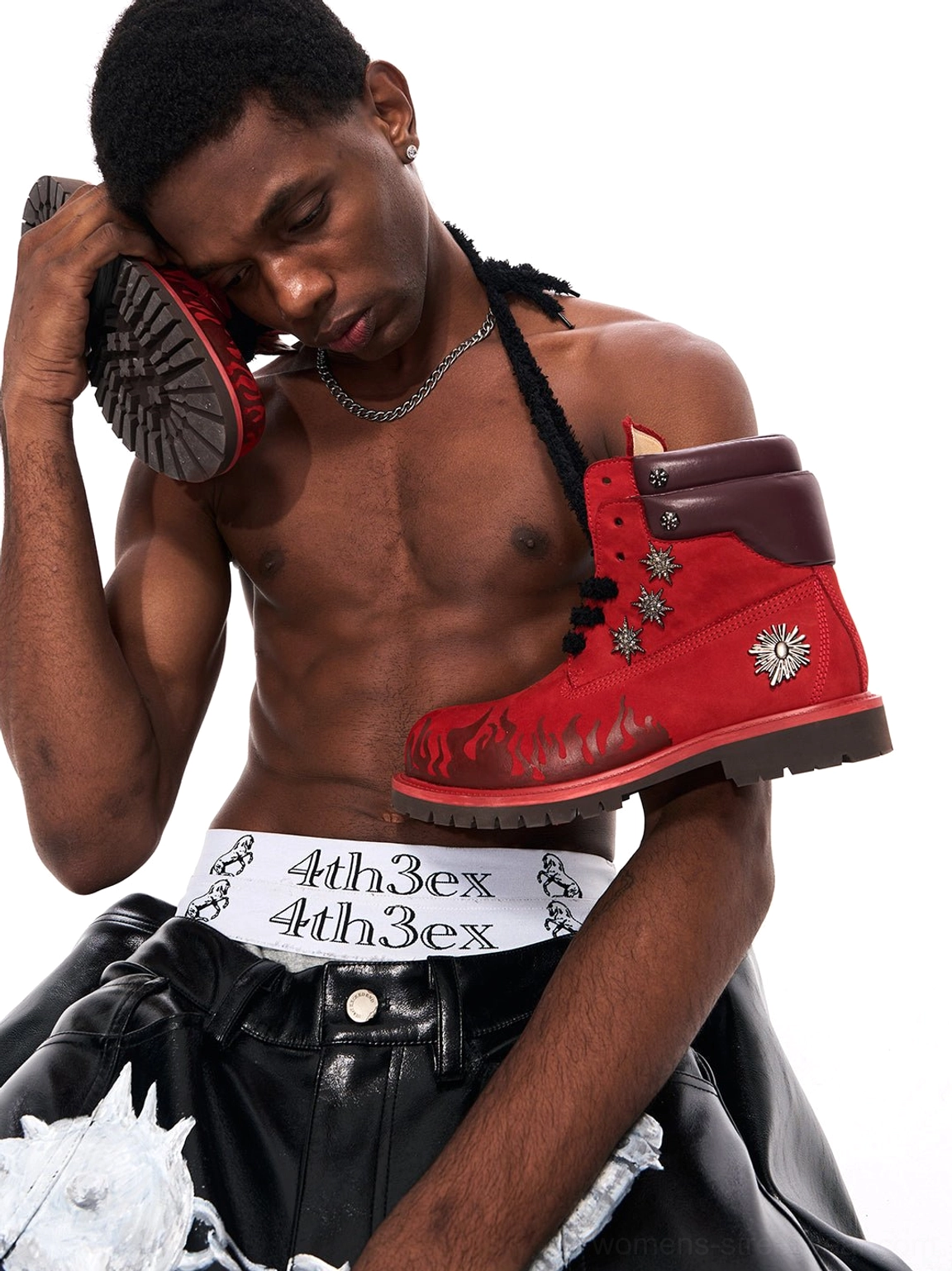 Close-up of red genuine leather flame appliqué combat boot upper with dark collar, black laces, and metallic decorative accents