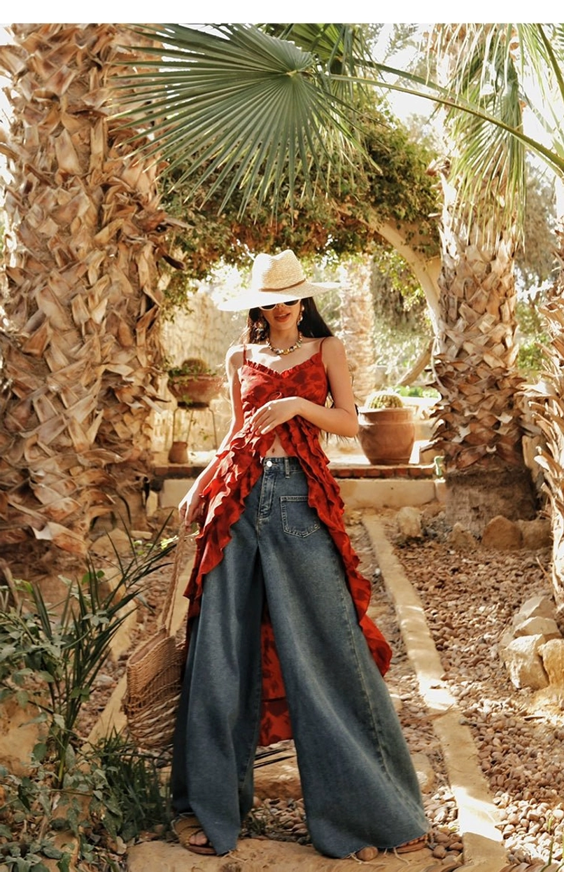 Red floral boho ruffle high-low camisole top front view with fitted spaghetti strap bodice and layered ruffled overlay in a sunny palm garden