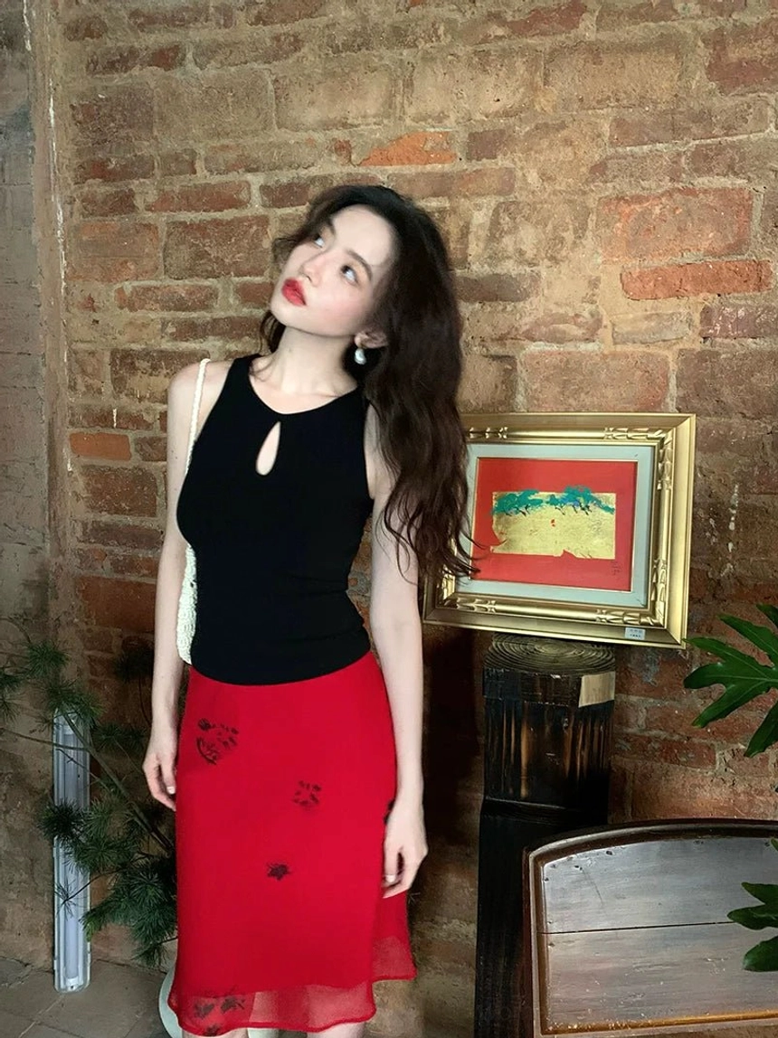 Red floral chiffon midi skirt with fitted bodycon silhouette and irregular ruffled hem styled in a vintage indoor streetwear setting