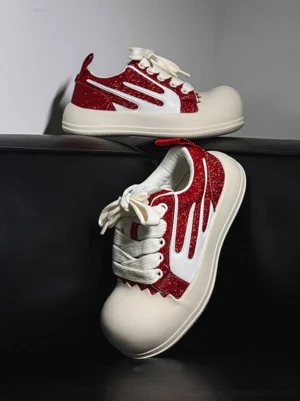 Red glitter chunky platform sneakers with oversized white rubber toe caps, white side stripes, flat laces and thick streetwear sole