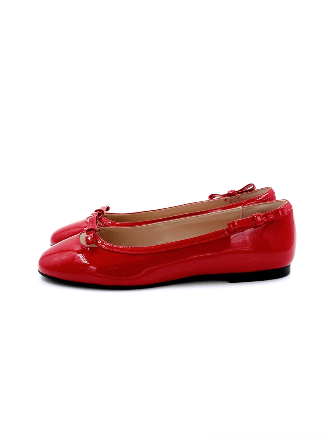 Red patent leather bow ballet flats in side profile with vibrant glossy finish, rounded toe, ruffled heel trim, heart-back accent, and flat sole