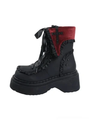 Red lace cross platform combat boot shown from a left three-quarter angle with black matte upper, red velvet cross collar, ruffled trim, satin laces, and chunky sole