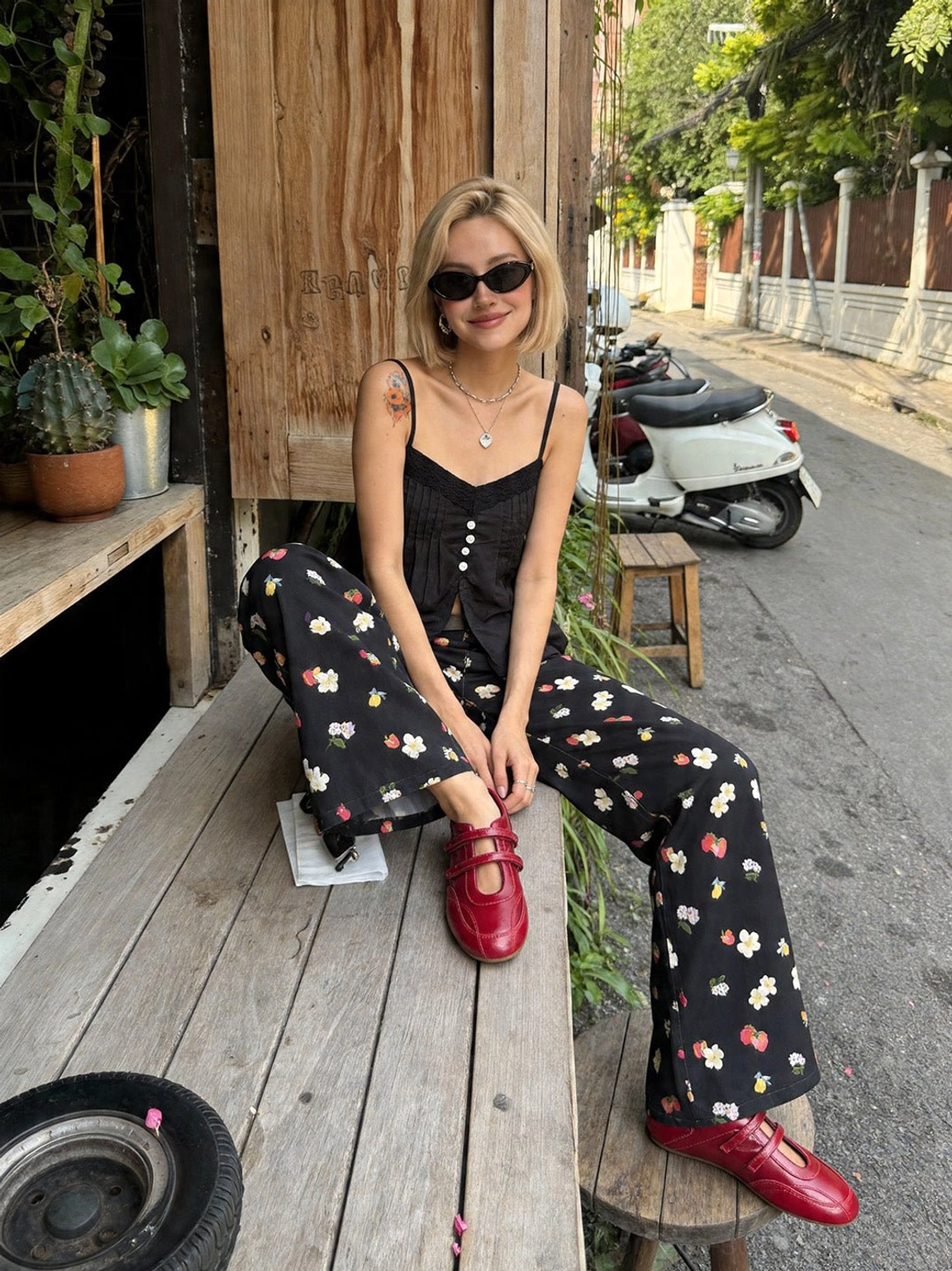 Close street style view of red leather-look flats with dual crossed straps and rounded toe