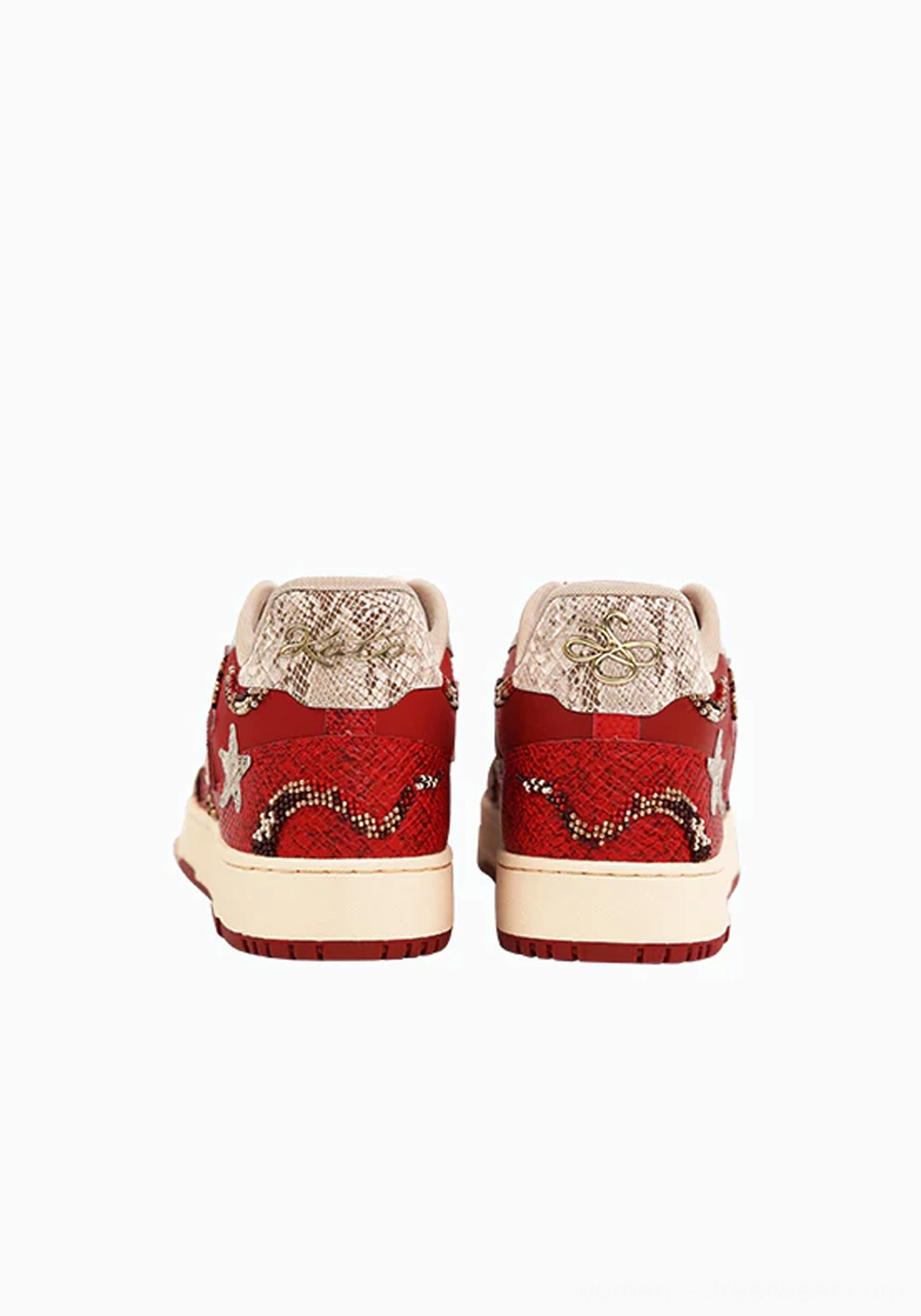 Red low-top snake-embossed court sneakers with textured textile upper, star decorations, and flat rubber sole
