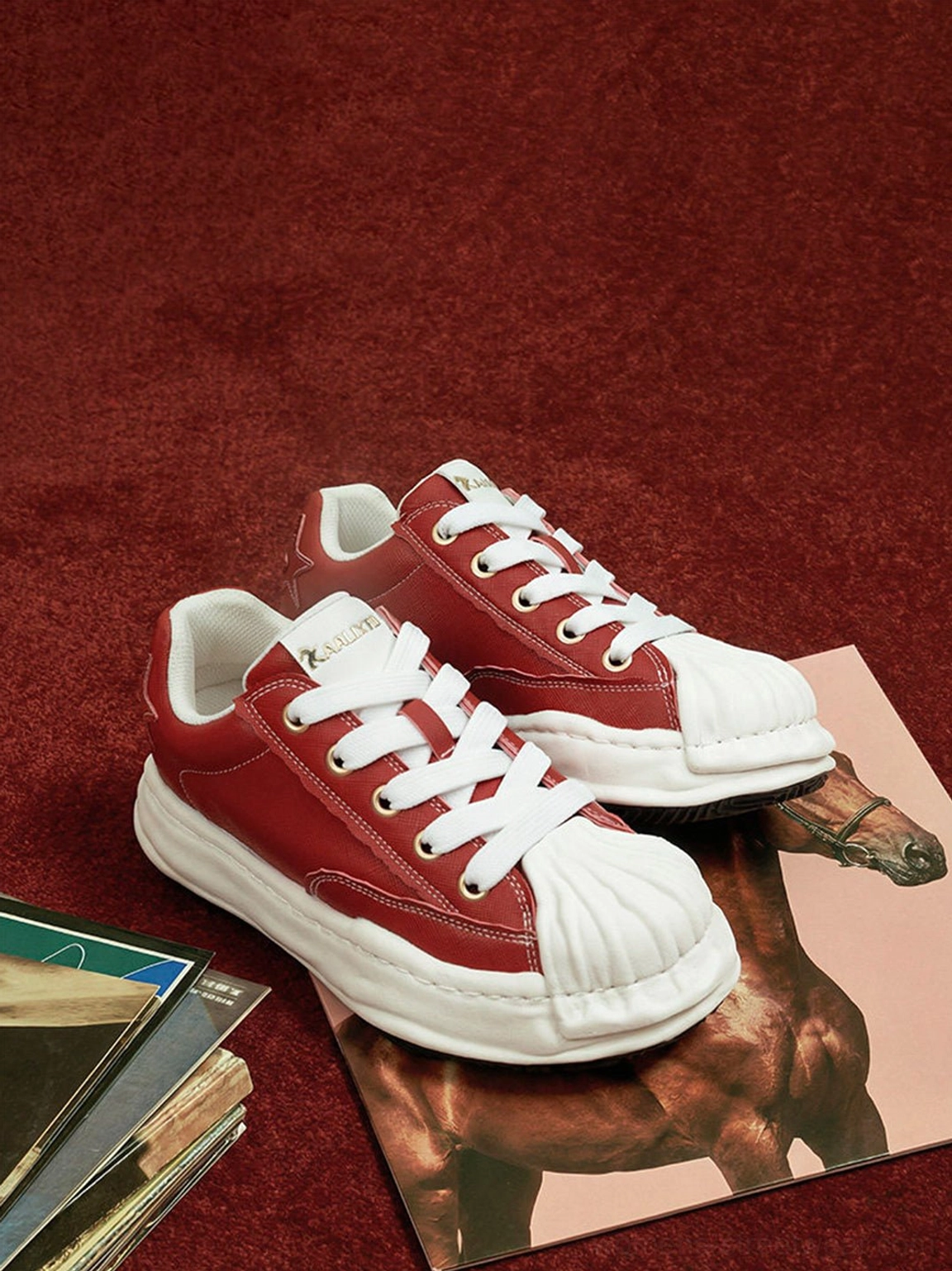 Two red molded-toe court sneakers shown from above beside vinyl records, highlighting the thick white midsole