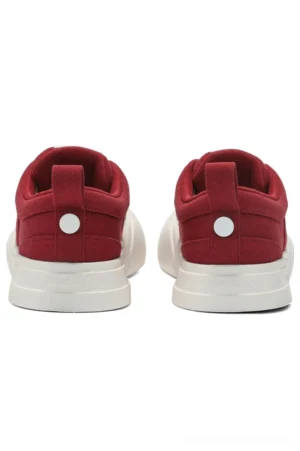 Rear view of red and off-white canvas low-top streetwear sneakers showing the textured rubber outsole, heel pull tabs, and decorative rear button detail