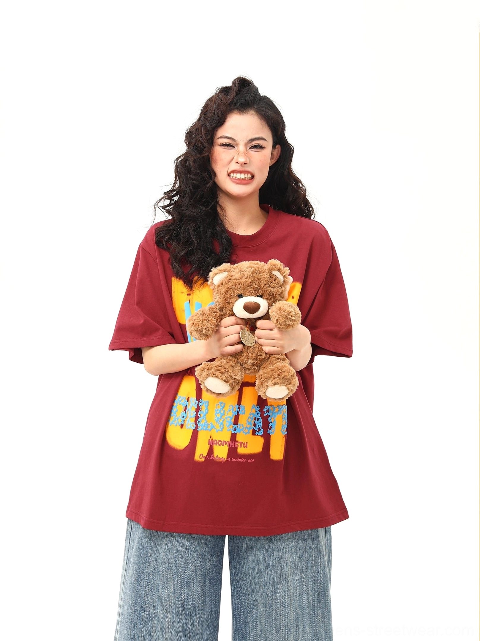 Red oversized teddy bear graphic T-shirt in a relaxed Y2K streetwear outfit with wide-leg denim
