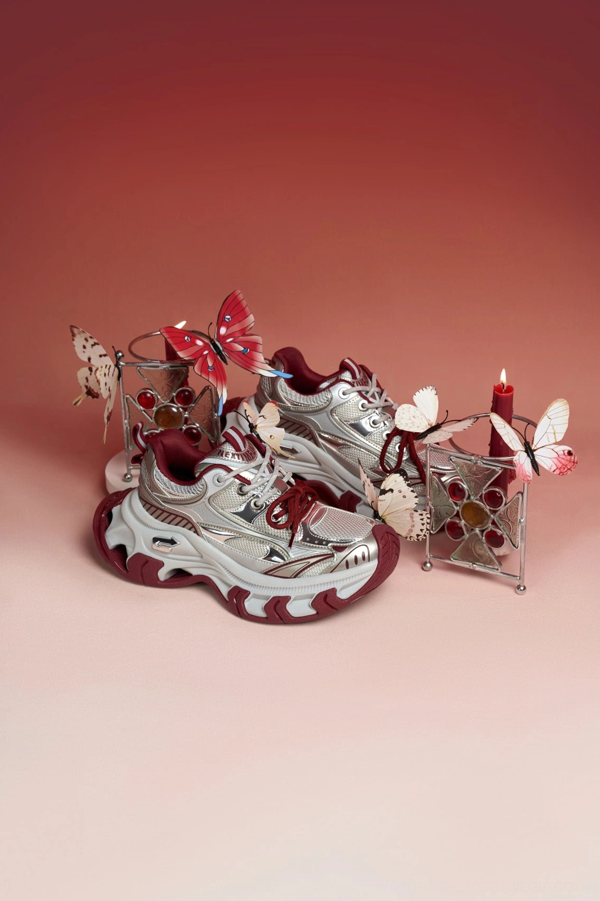 Fashion-forward red metallic platform sneakers with silver upper, burgundy outsole, and bold avant-garde streetwear styling