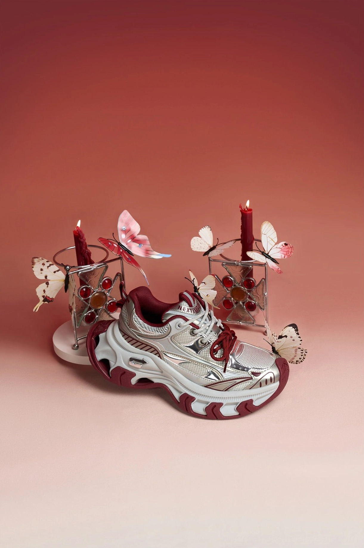 Side view of red Papillon metallic platform sneakers showing the sculpted chunky sole, burgundy outsole, and layered sneaker construction