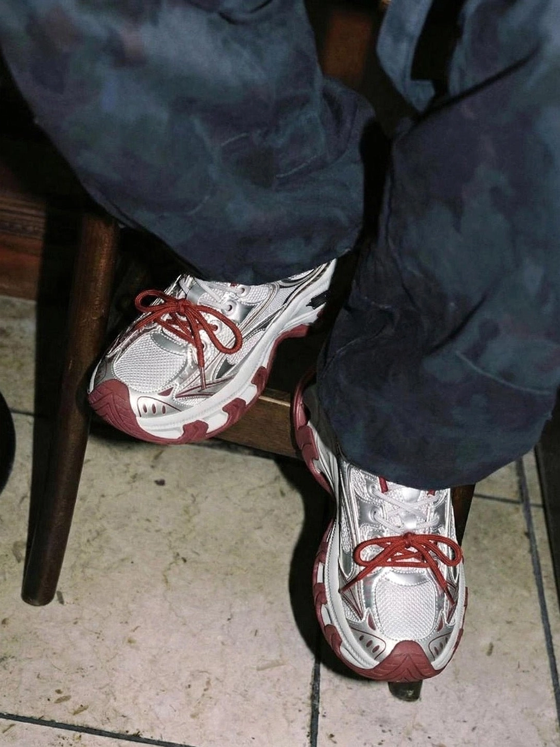 Red Papillon platform sneakers styled with dark tie-dye jeans, showing the chunky layered sole and silver streetwear sneaker upper