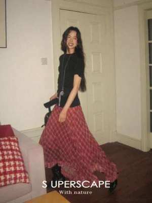 Red plaid asymmetric layered chiffon skirt shown from a side angle with a flowing streetwear maxi silhouette
