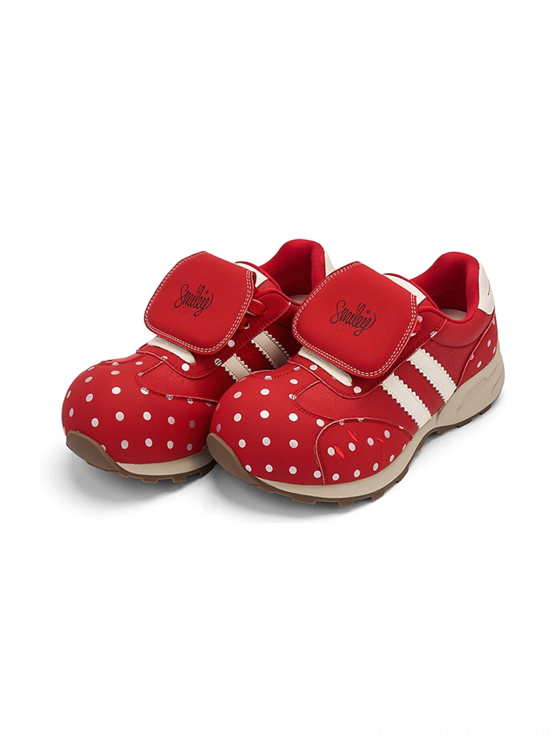 Front three quarter view of red polka dot platform sneakers with embroidered hook and loop strap detail