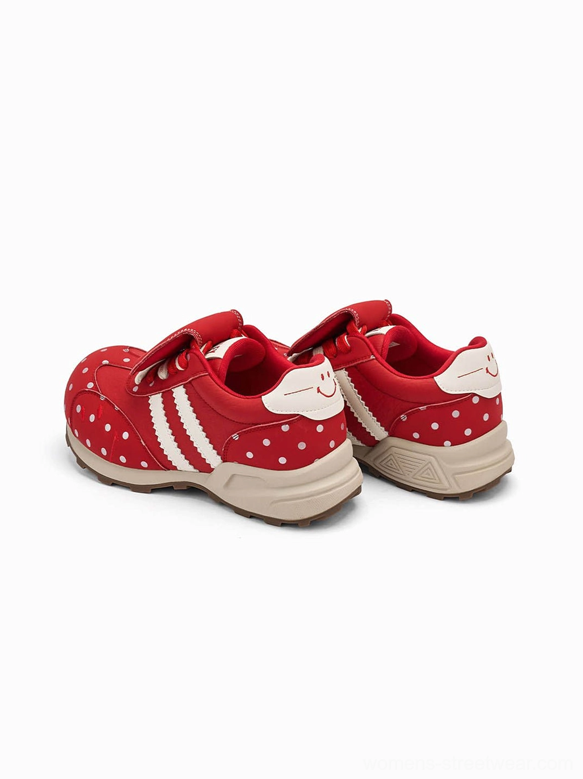 Top view of red polka dot sneakers showing the smiling heel tab and contrasting white side stripes