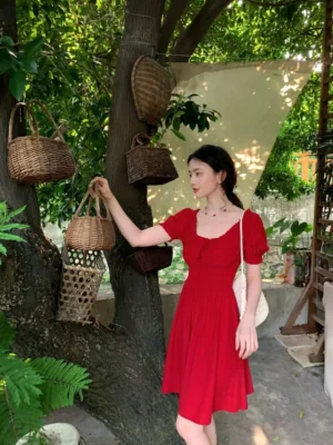 Red puff sleeve smocked waist mini dress with a square neckline and romantic A-line silhouette styled outdoors with a white crossbody bag