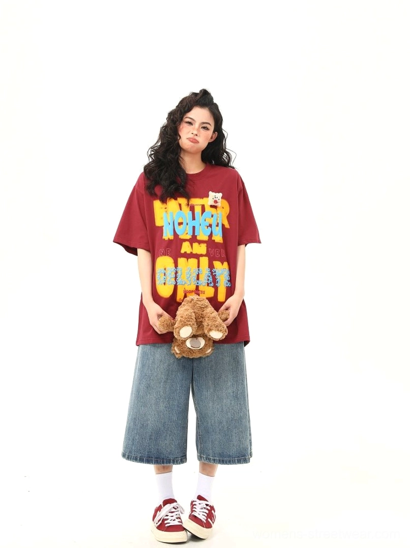 Full length front view of red retro graphic oversized T-shirt with colorful lettering and teddy bear patch