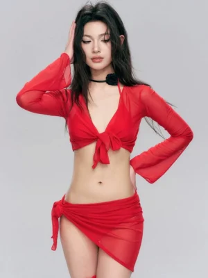 Front view of red sheer tie-front long sleeve crop top and asymmetric wrap mini skirt set in Y2K streetwear styling