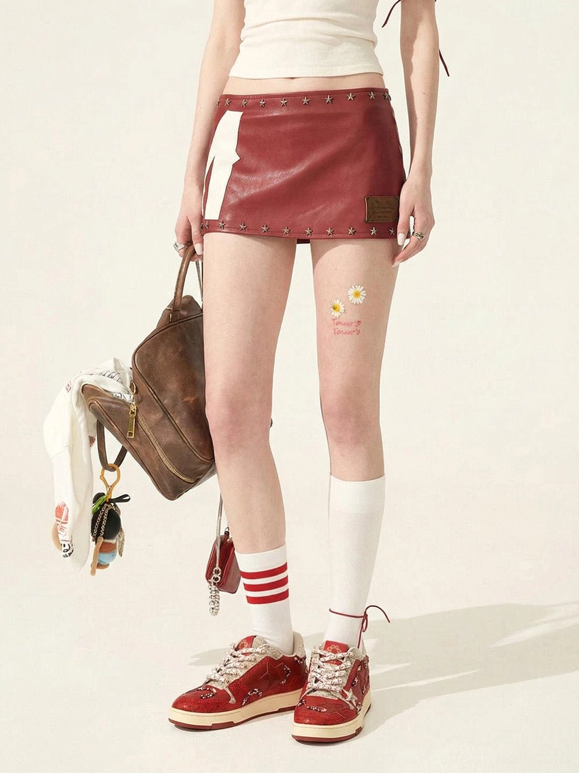 Full lower-body Y2K outfit featuring red snake-embossed star court sneakers and a red leather mini skirt