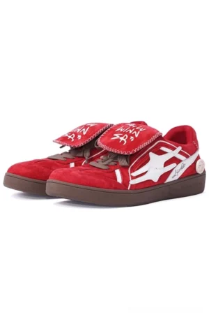 Red suede court sneakers in a front side view with white star-shaped side logo, graffiti tongue text, and brown gum rubber outsole