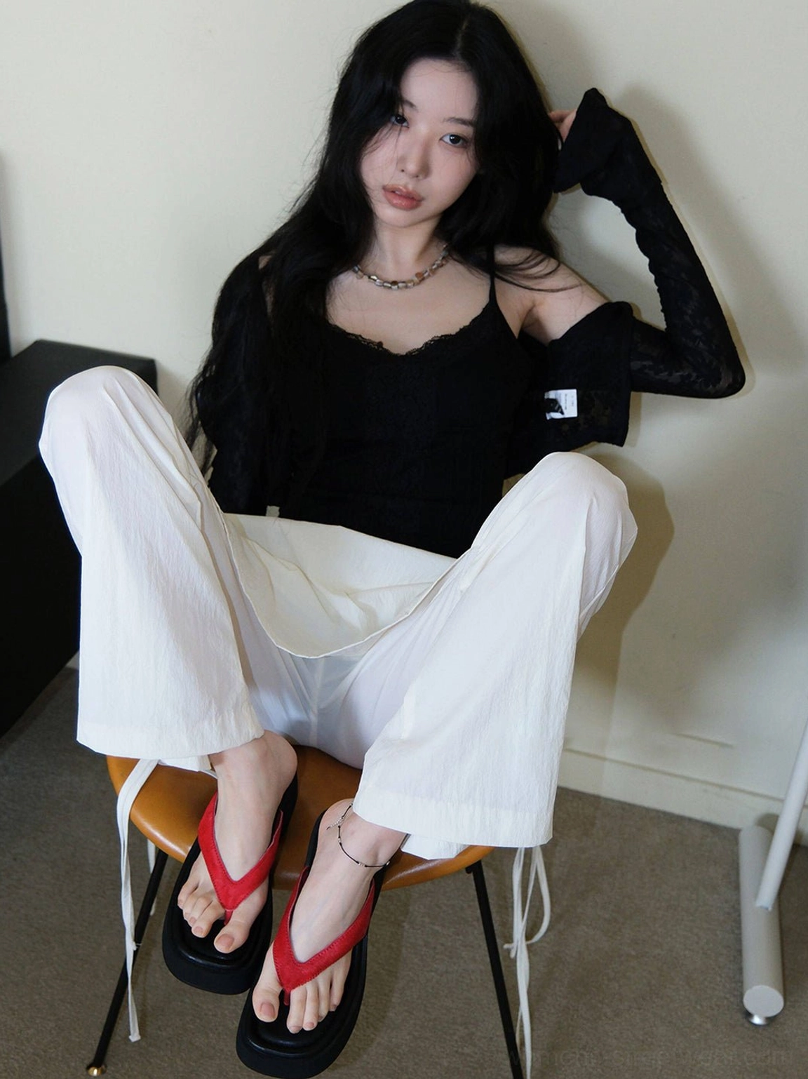 Red suede toe strap platform flip-flops styled with black camisole and white wide-leg pants