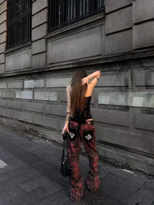 Back view of red tartan wide leg streetwear pants with black back pockets and embroidered white gothic emblem details