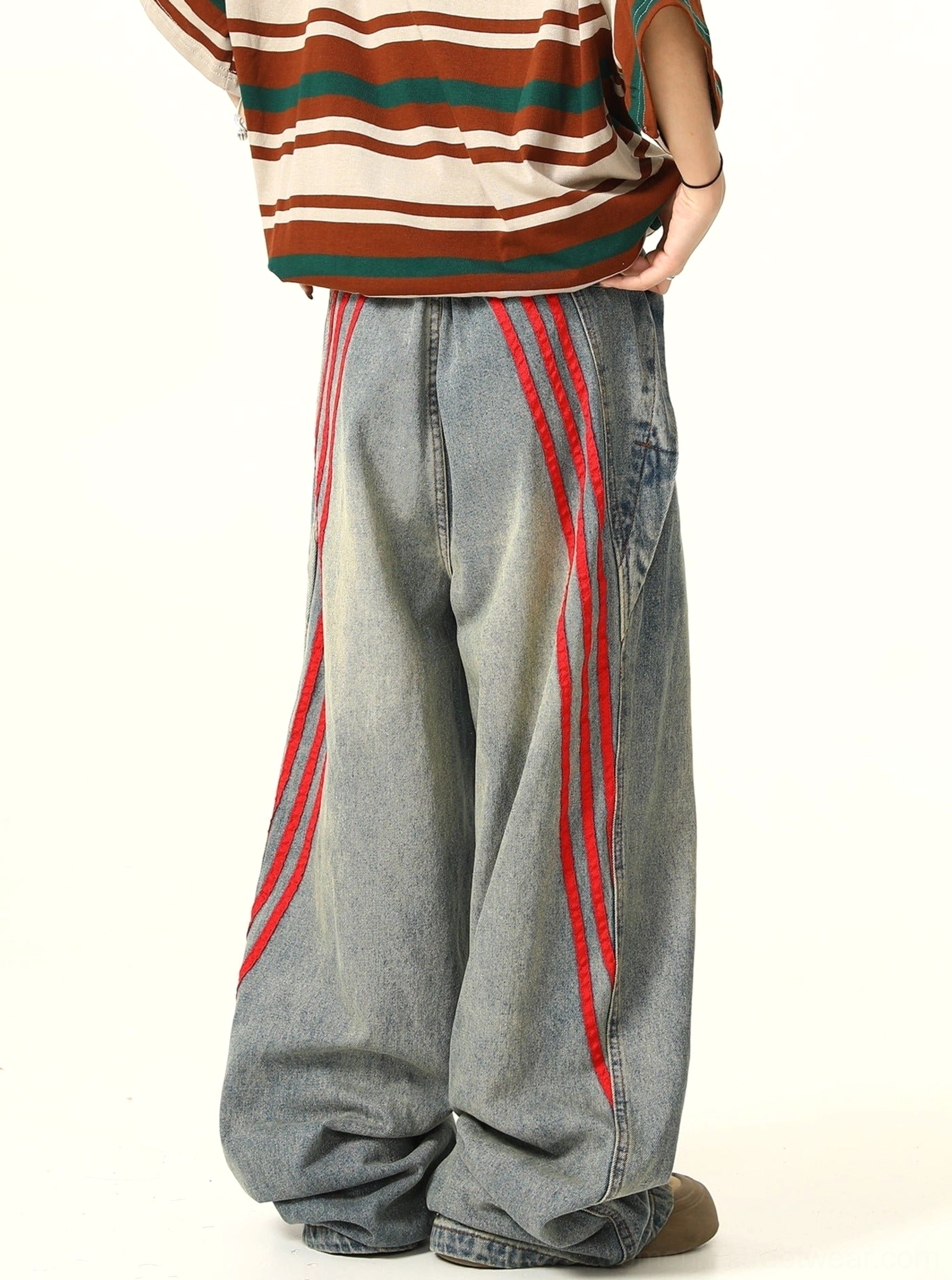 Full back view of relaxed wide-leg light blue jeans featuring red outer-leg stripes, back pockets, and vintage streetwear styling
