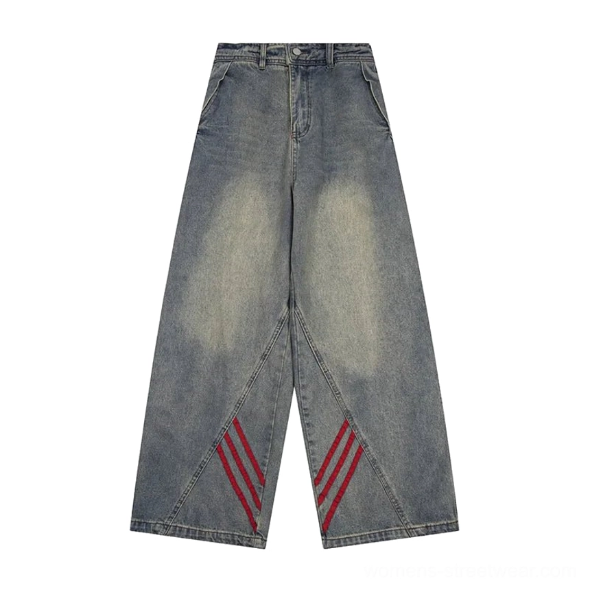 Flat lay display of vintage blue wide-leg denim jeans with red diagonal stripe accents, classic hardware, and relaxed streetwear fit