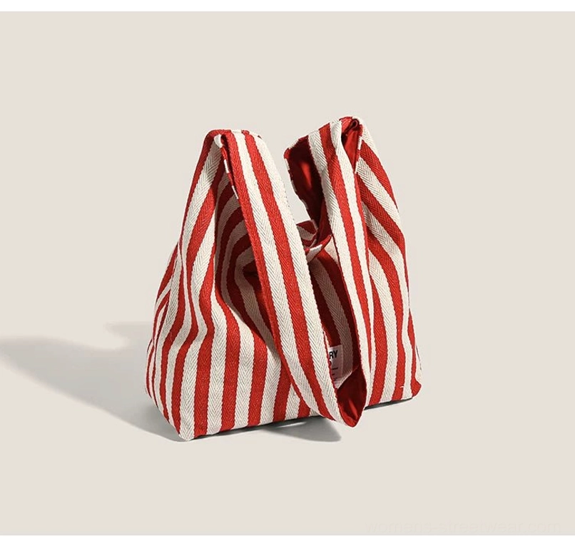 Back and overhead view of red and white striped canvas hobo shoulder bag with thick woven strap